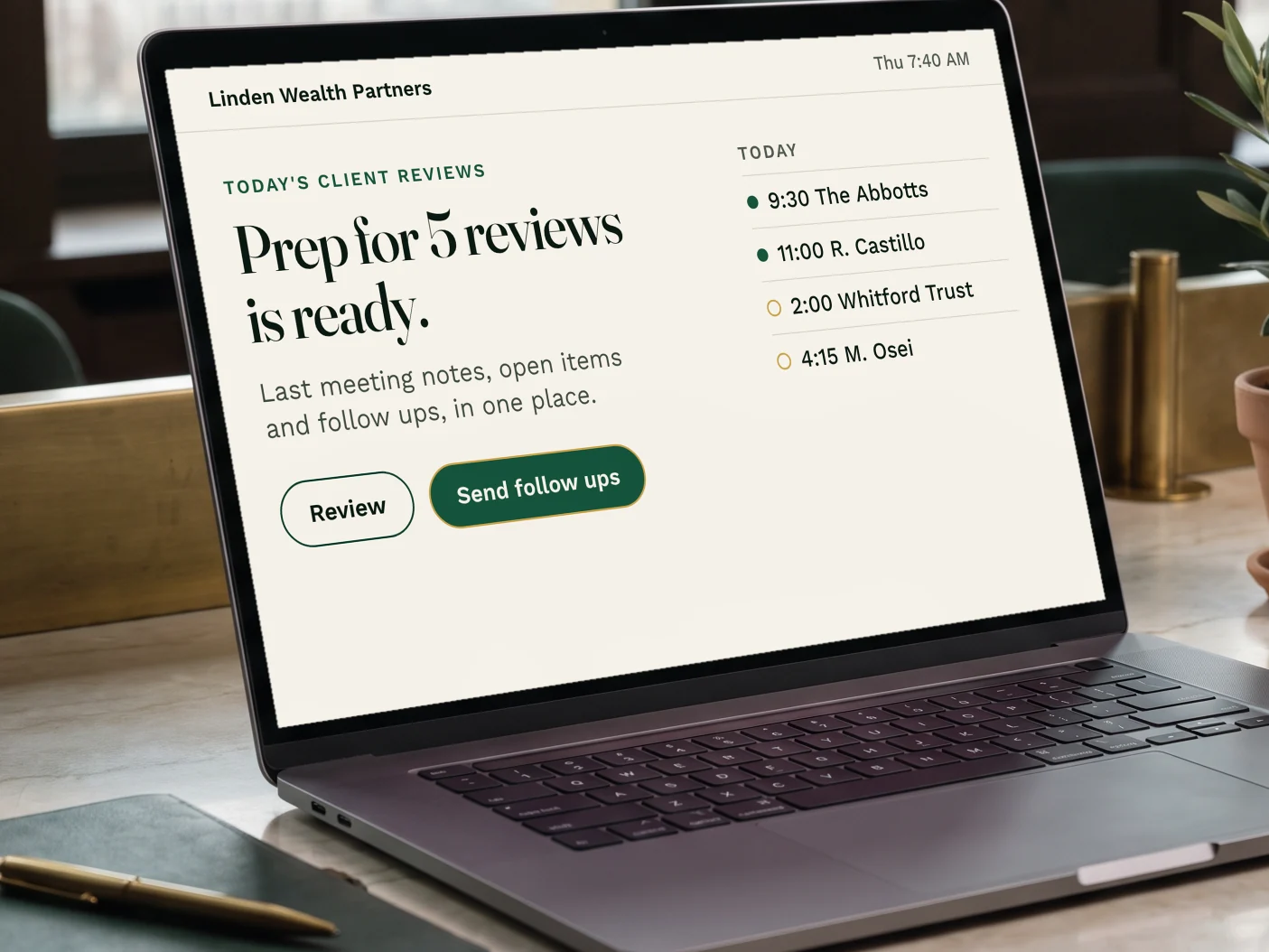 A laptop on an advisor's desk showing client review prep and meeting follow ups ready to send.